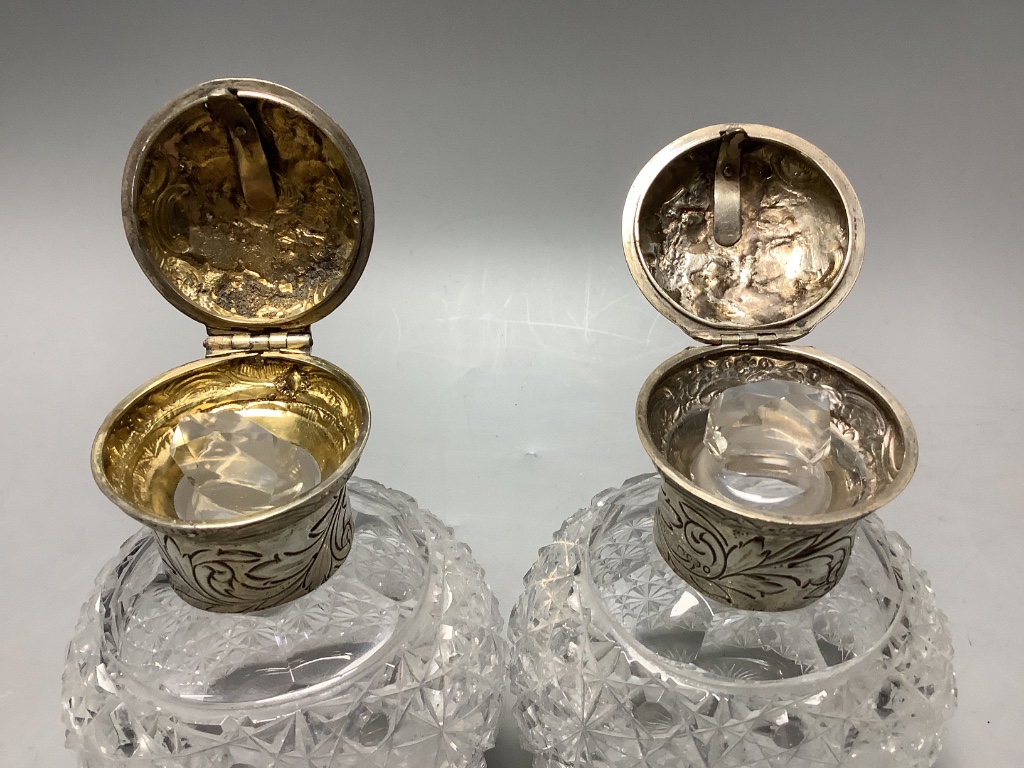 A pair of late Victorian silver mounted cut glass scent bottles, London, 1887, height 13.1 cm and a silver and tortoiseshell powder jar.